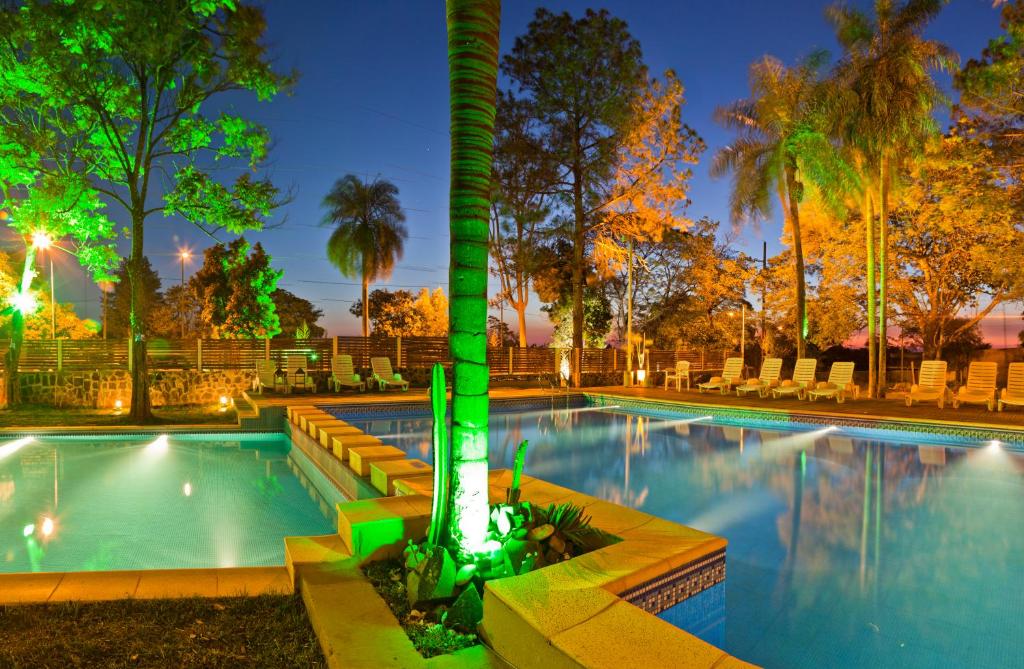波萨达斯拉米森波萨达斯酒店的游泳池在晚上,中间有棕榈树