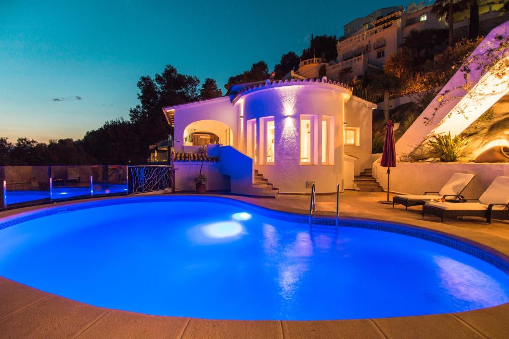 莫莱拉Casa Infinidad的夜间在房子前面的游泳池