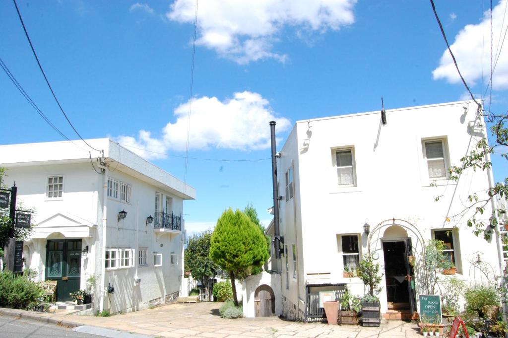 镰仓市Kamakurayama Holiday Flat的街道上两栋彼此相邻的白色建筑