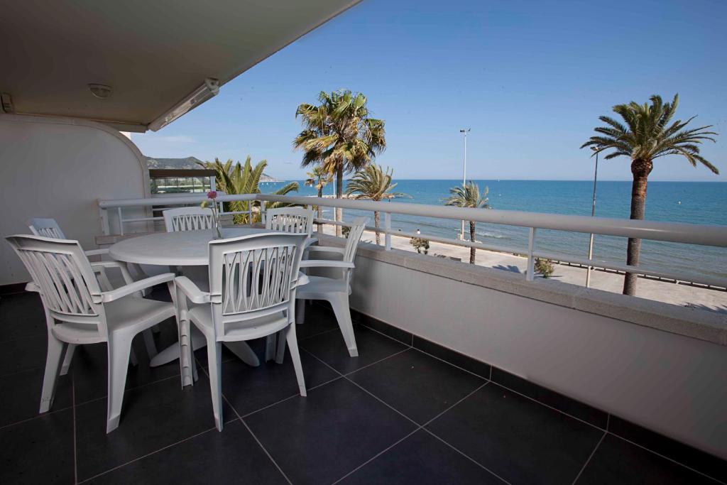 锡切斯Apartamentos Sunway Talaia的一个带桌椅的海景阳台