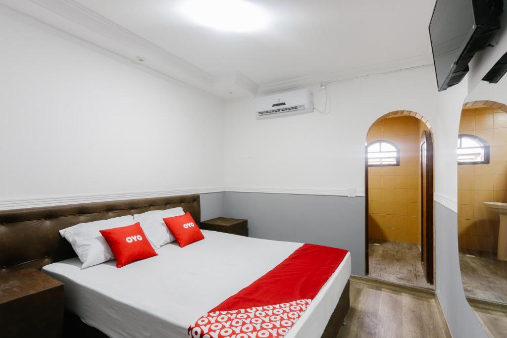 圣保罗OYO Hotel San Remo, São Paulo的一间卧室配有红色枕头的床