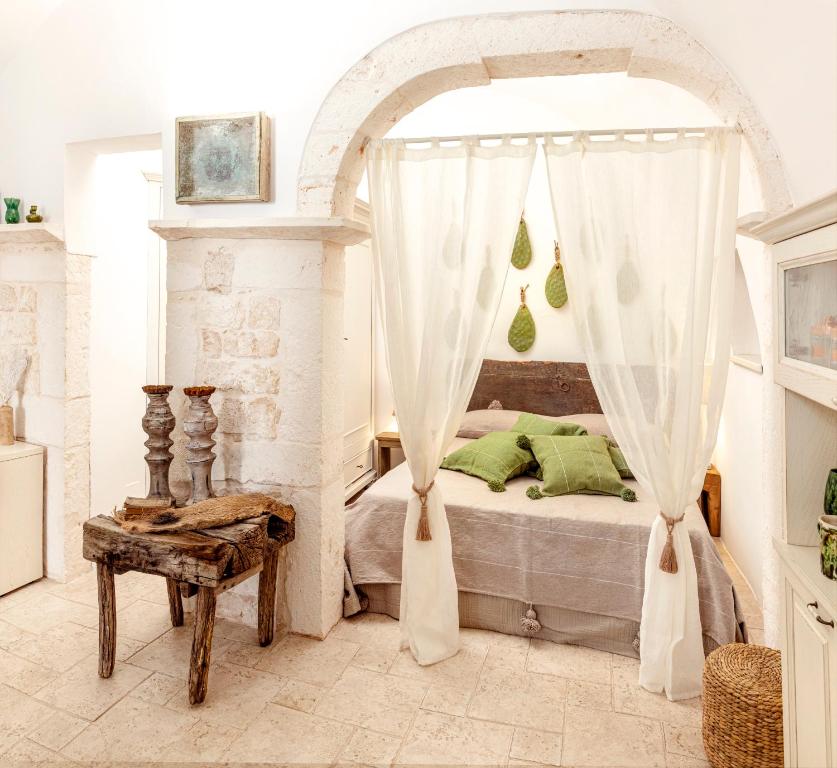 奥斯图尼Alesia luxury suite Ostuni的一间卧室配有一张带天蓬的床
