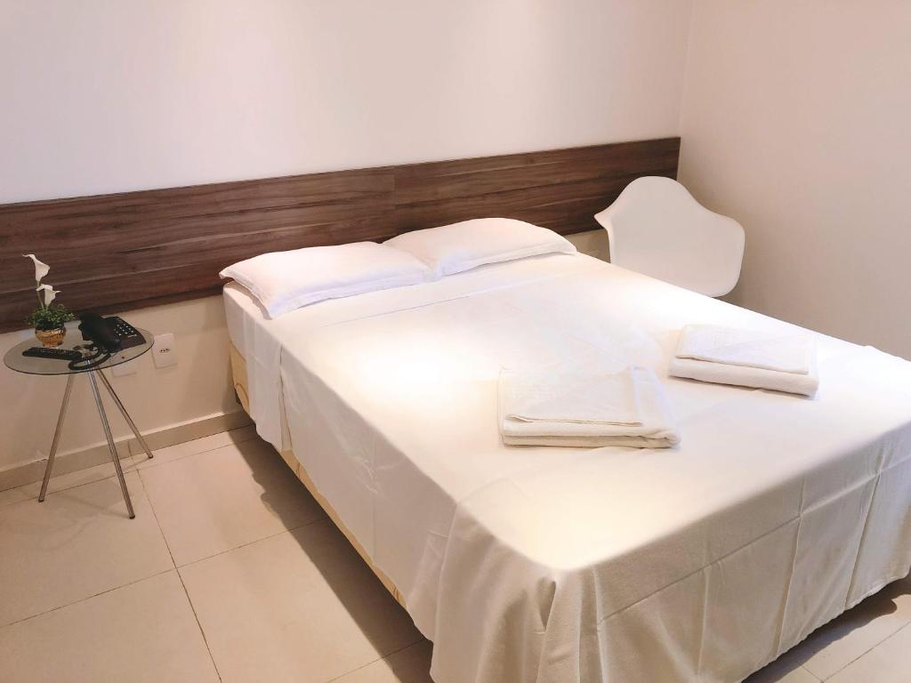福塔莱萨Angra Praia Hotel的一张白色大床,配有白色床单和桌子