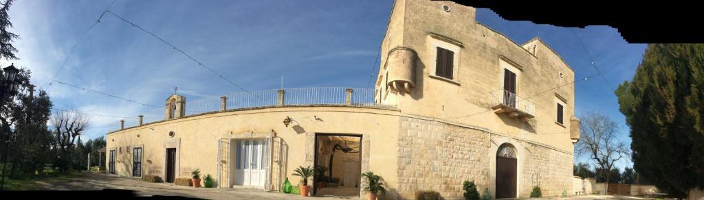 科拉托Farm Agriturismo Masseria Chiusurella的一座大型石头建筑,上面有门