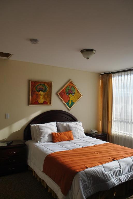 拉塔昆加MAK INN HOUSE的一间卧室配有一张带橙色毯子的大床