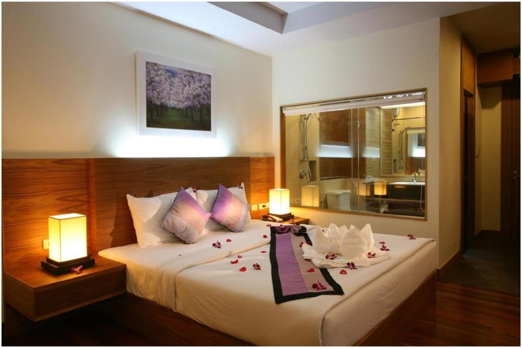 象岛坝安塞考广场酒店及服务式公寓的一间卧室配有一张带鲜花的大床