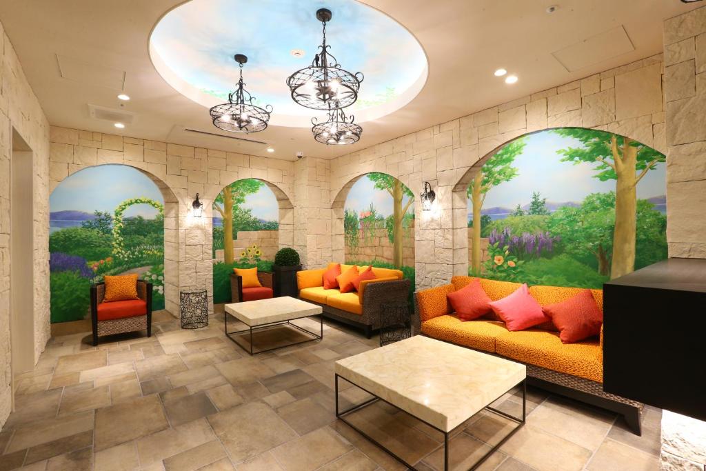 名古屋名古屋荣永安国际酒店的大堂设有橙色沙发和壁画