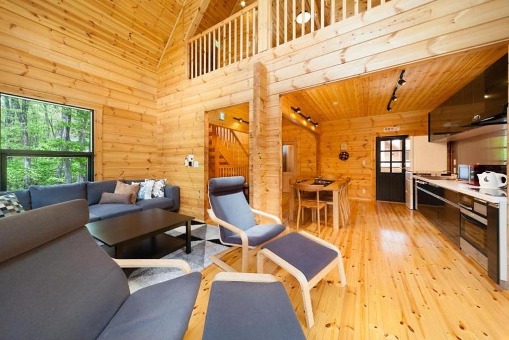白马村Wadano Woods by Hakuba Hotel Group的小木屋客厅配有沙发和桌子