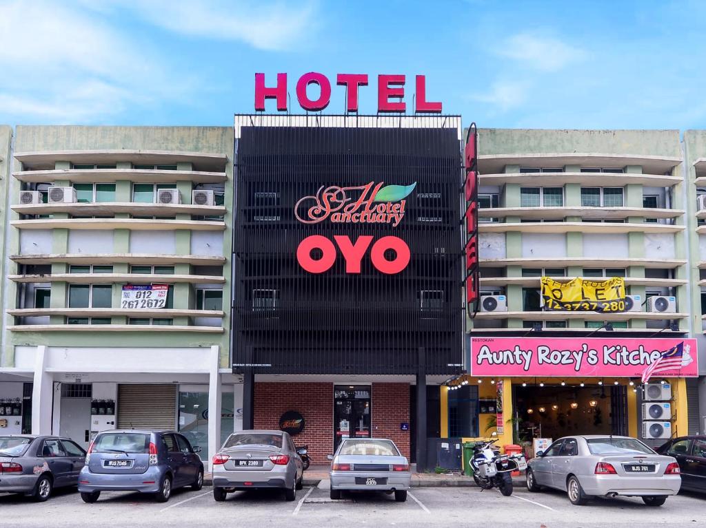 八打灵再也OYO 876 Hotel Sanctuary的停车场内有车辆的旅馆