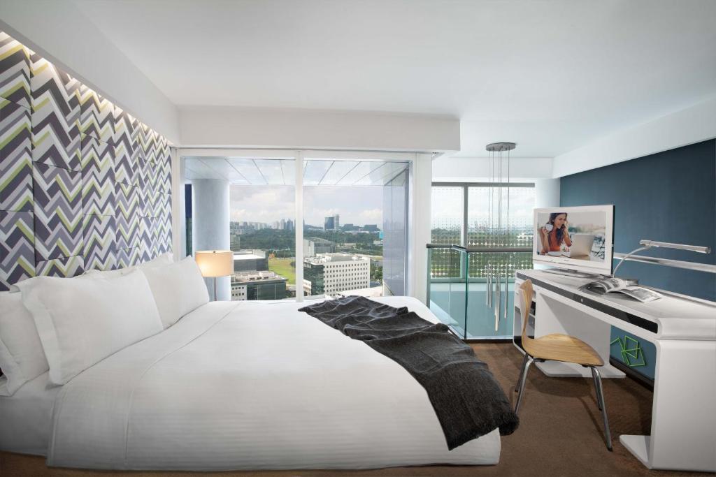 新加坡Citadines Fusionopolis Singapore的卧室配有一张白色大床和一张书桌