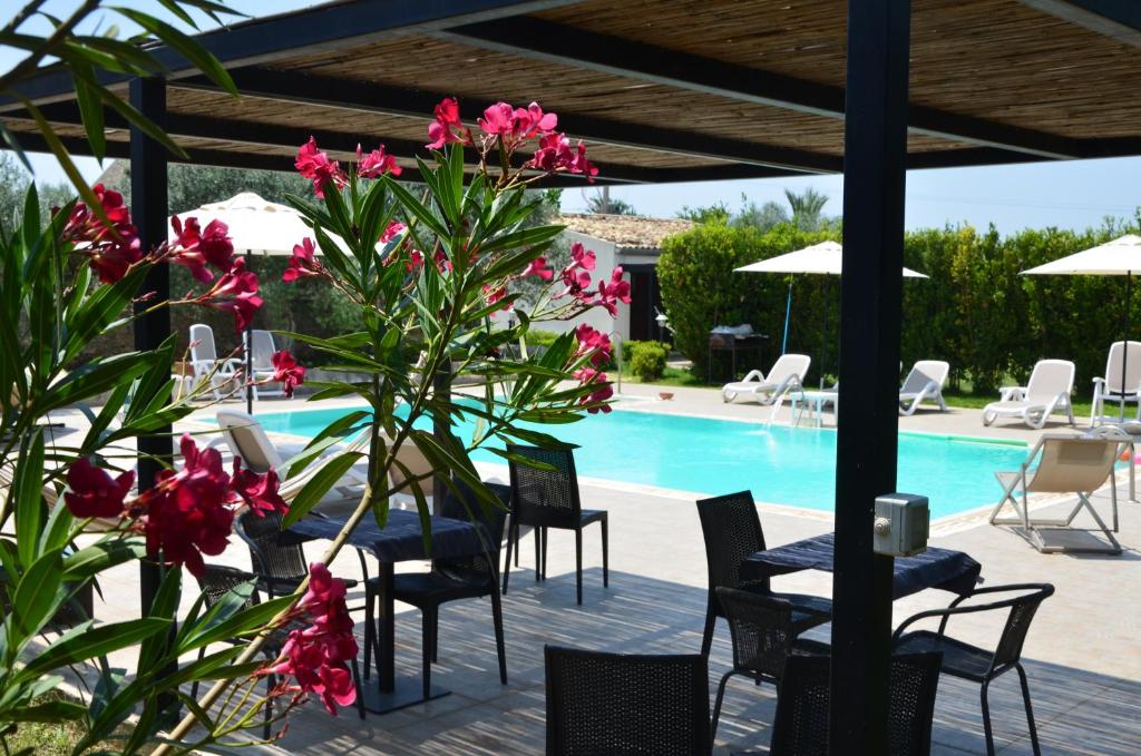 基亚拉蒙泰-古尔菲Serravalle Relais & Country Villa with private pool - Esclusive use的一个带桌椅的游泳池以及粉红色的鲜花