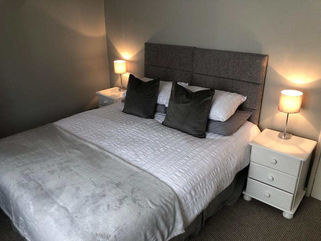 达灵顿34 Brunton Street Serviced Accommodation的一间卧室配有一张带2个床头柜的大床