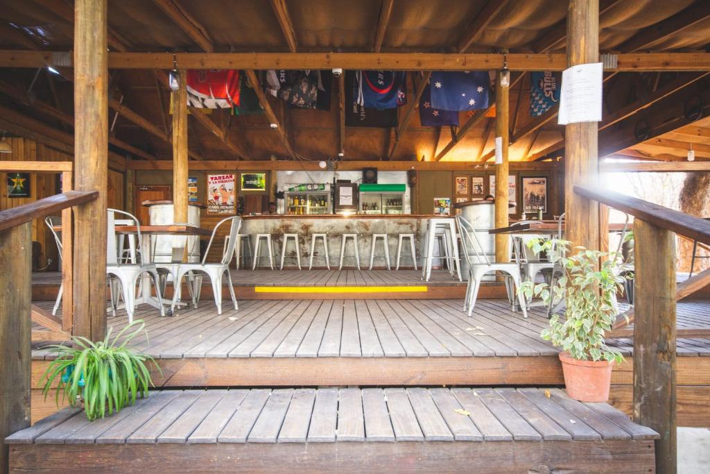 马翁Sitatunga Campsite Maun的一间设有白色椅子的餐厅和一间酒吧