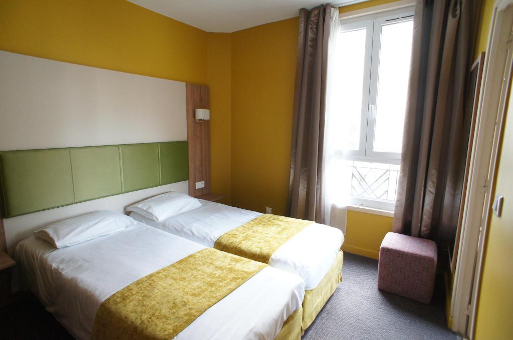 布洛涅-比扬古法国酒店的酒店客房设有两张床和窗户。