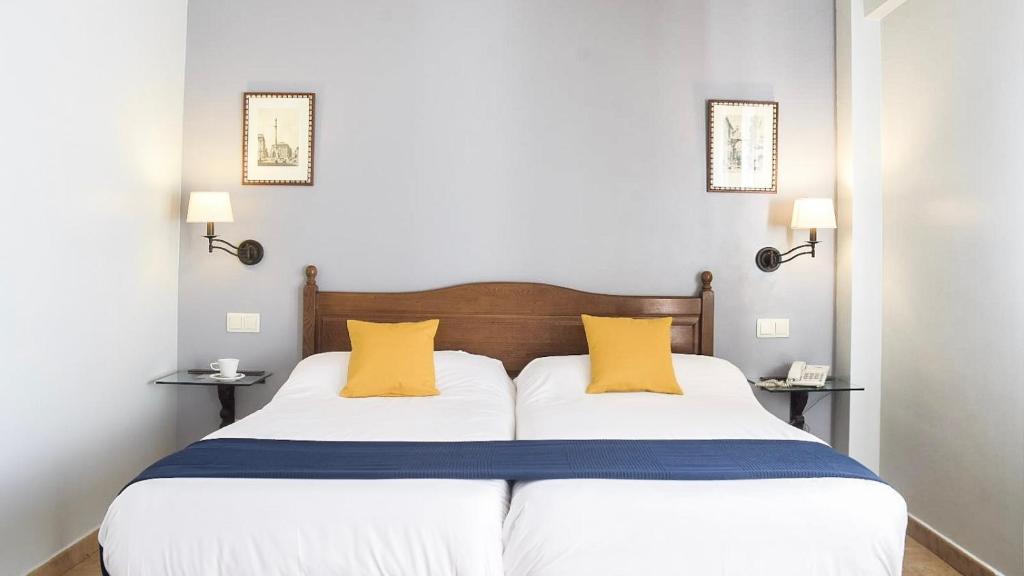 托雷洪-德阿尔多斯Villa Soledad的一间卧室配有一张大床和两张黄色枕头