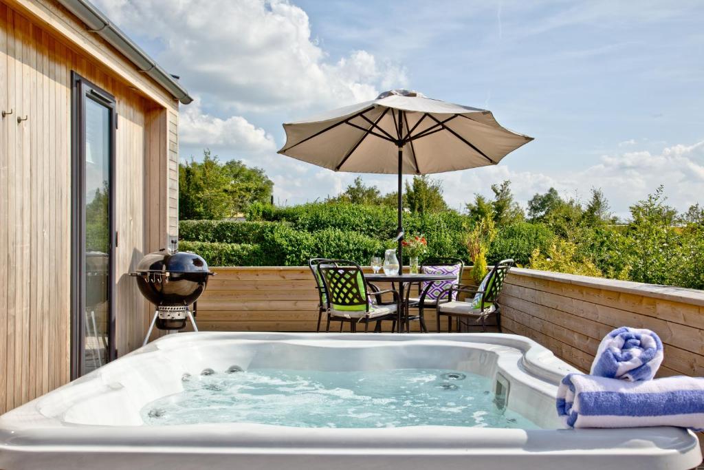 切达Perry Lodge, Strawberryfield Park的庭院内的热水浴池和遮阳伞