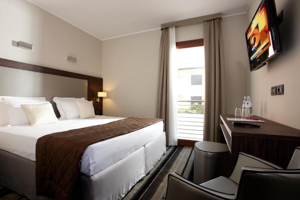 泰塞拉BEST WESTERN Titian Inn Hotel Venice Airport的酒店客房配有一张床、一张书桌和一台电视。