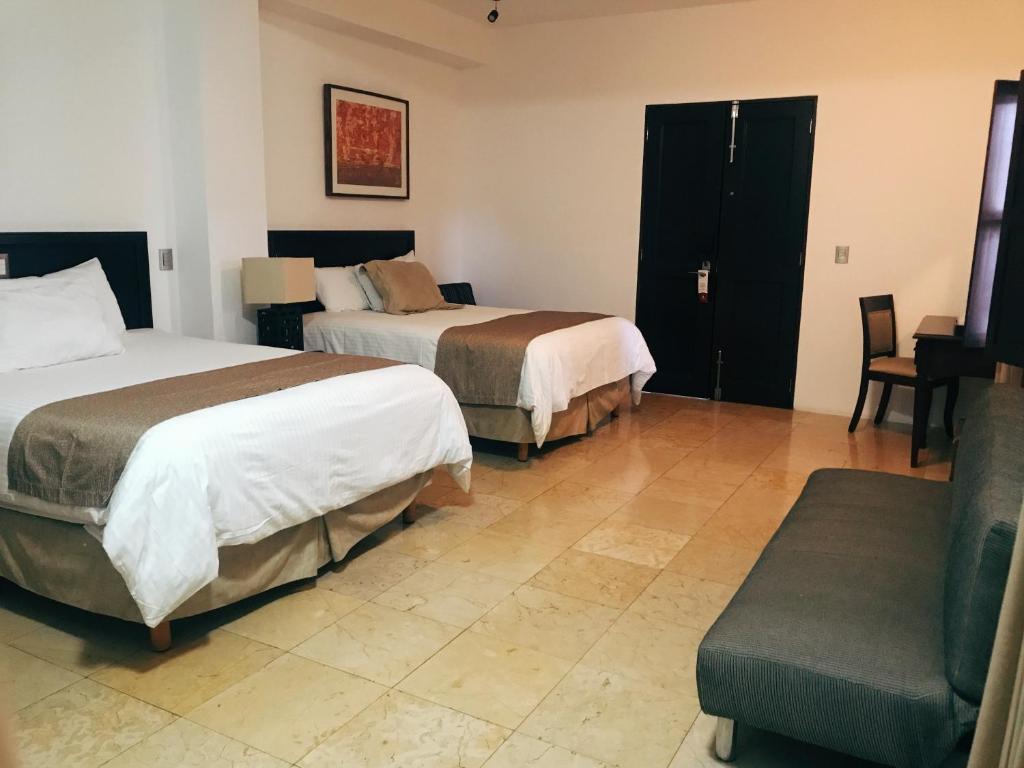 瓦哈卡市Hotel Casa las Mercedes的酒店客房,设有两张床和一张沙发