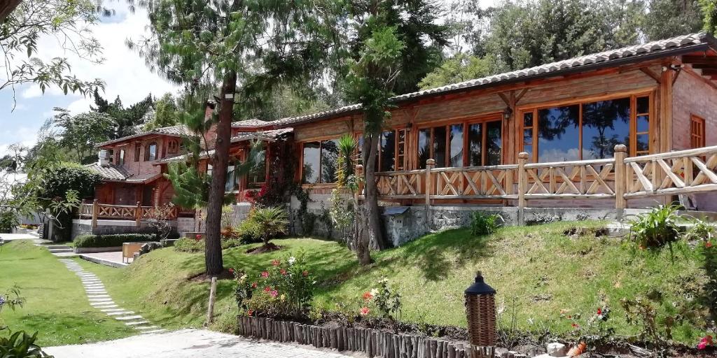 基多La Casa del colibri ecuador的草木山丘上带花园的房子