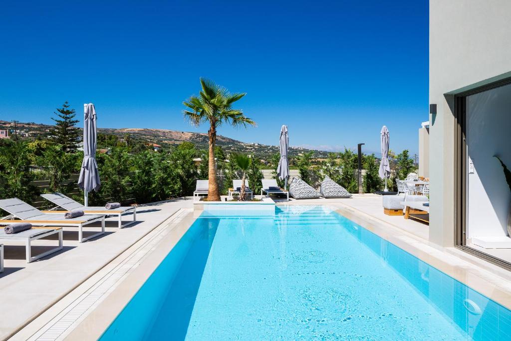 卢特拉Vasilios Villa, Luxury Escape, By ThinkVilla的一个带躺椅的游泳池和别墅