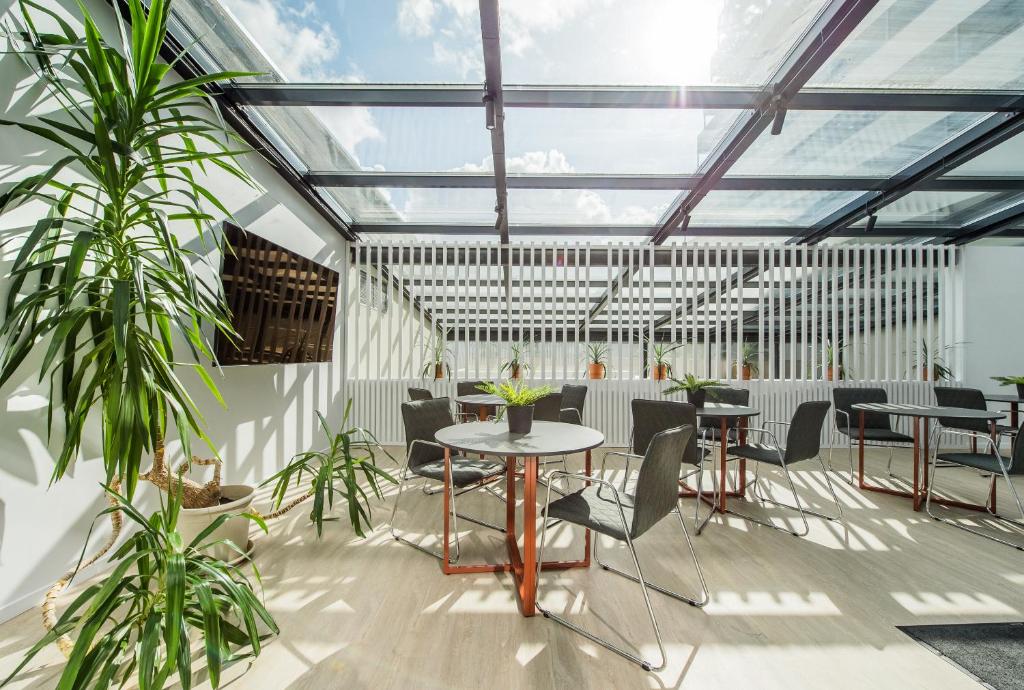 考纳斯Zaliakalnio terasos apartamentai的一个带桌椅和植物的温室