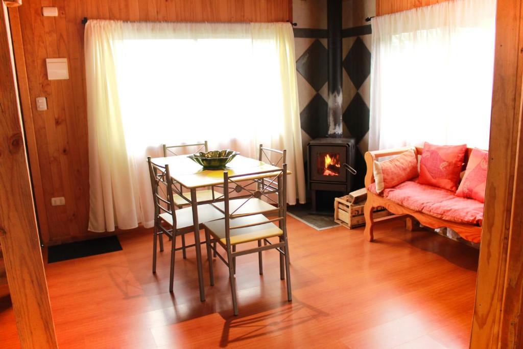 柯纳里佩Cabanas L'ESCALE的客厅配有桌子、沙发和壁炉