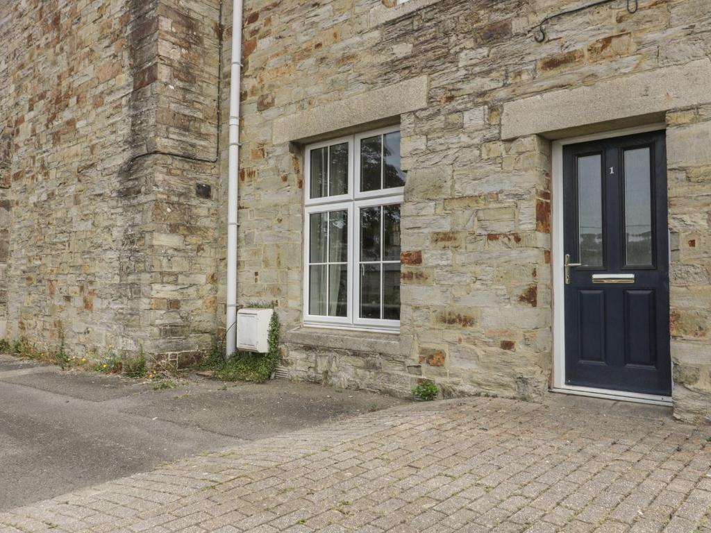 博德明Cherrywood Manor的蓝色门和窗户的砖砌建筑