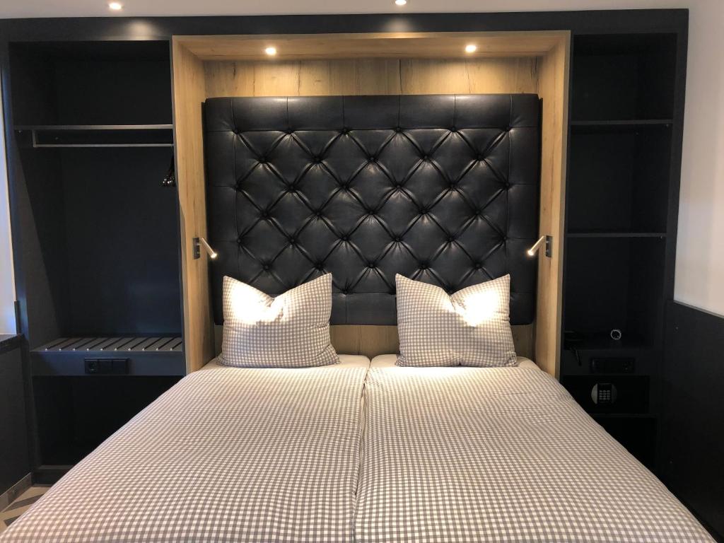 慕尼黑Munich Deluxe Hotel的一张带黑色床头板和两个白色枕头的床