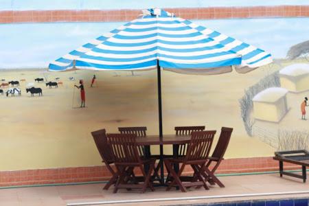 Sultan HamudMiryams Village Inn Safari Lodge的海滩上的桌椅和遮阳伞