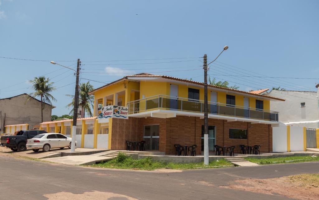 索雷Suítes Soure的街道边的黄色建筑