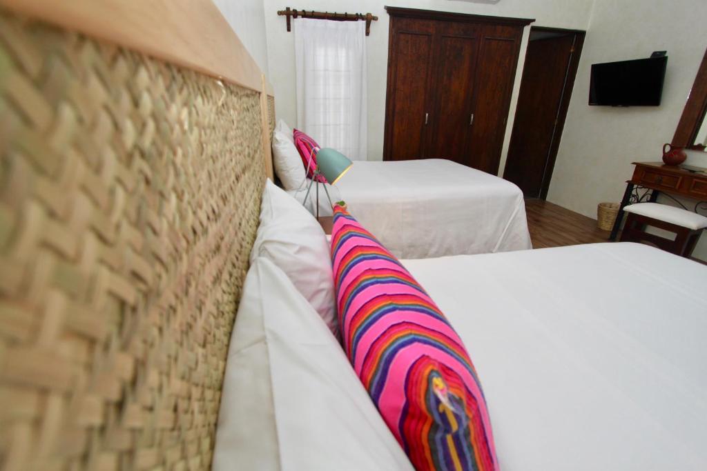 瓦哈卡市特雷沃尔酒店的酒店客房配有两张带条纹枕头的床