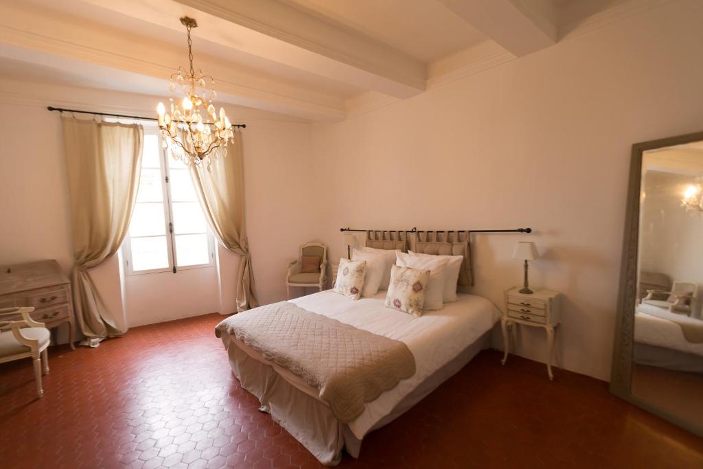屈屈龙Les Chambres De Charlotte的一间卧室配有一张床和一个吊灯