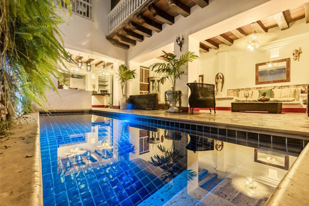 卡塔赫纳Hotel Casa la Tablada的蓝色瓷砖地板房子内的游泳池