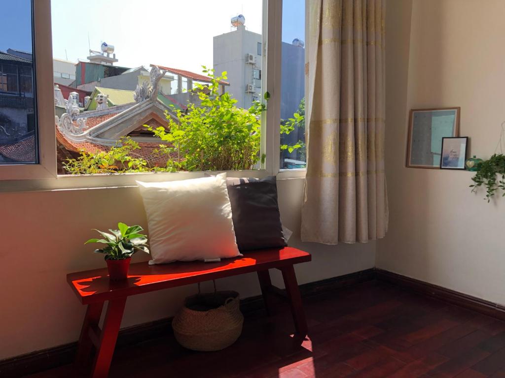 河内Khai Homestay的一个带长凳和植物窗户的房间