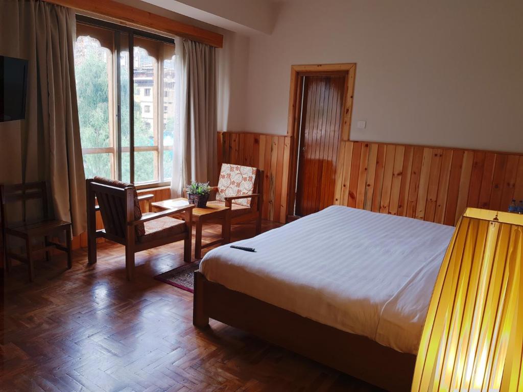 廷布卡木肃穆旅馆的卧室配有床、椅子和窗户。