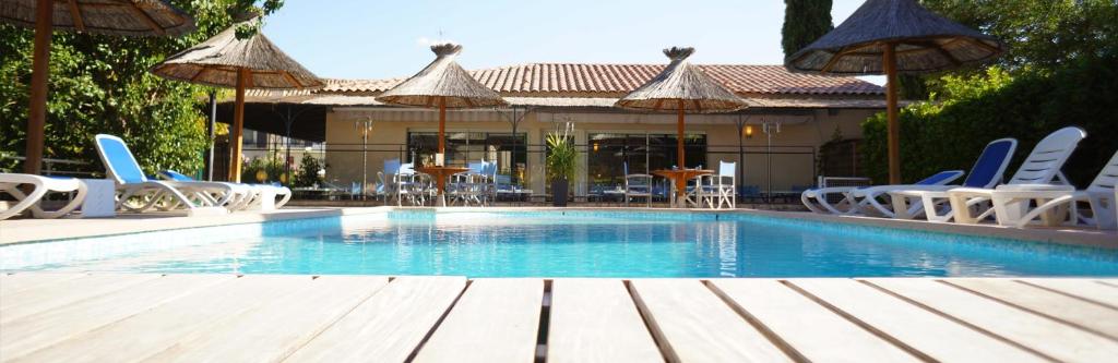 格雷乌莱班阿尔卑斯酒店的一个带桌椅和遮阳伞的游泳池