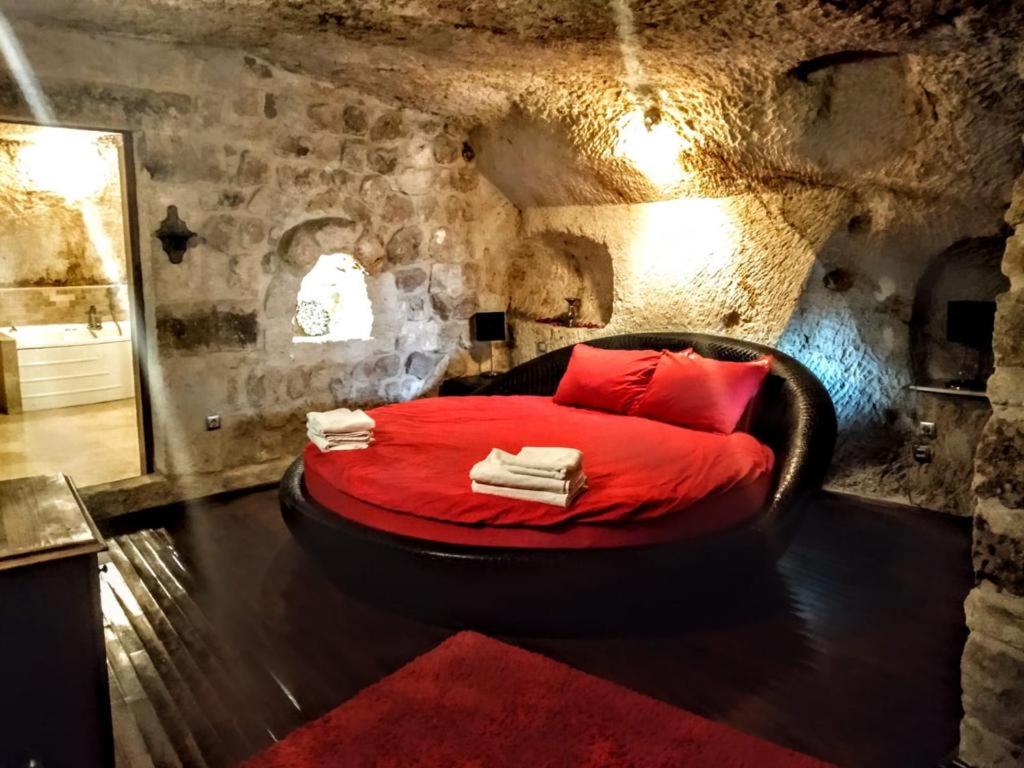 于尔居普ROCA CAPPADOCIA的石头房里一间设有红色床的卧室