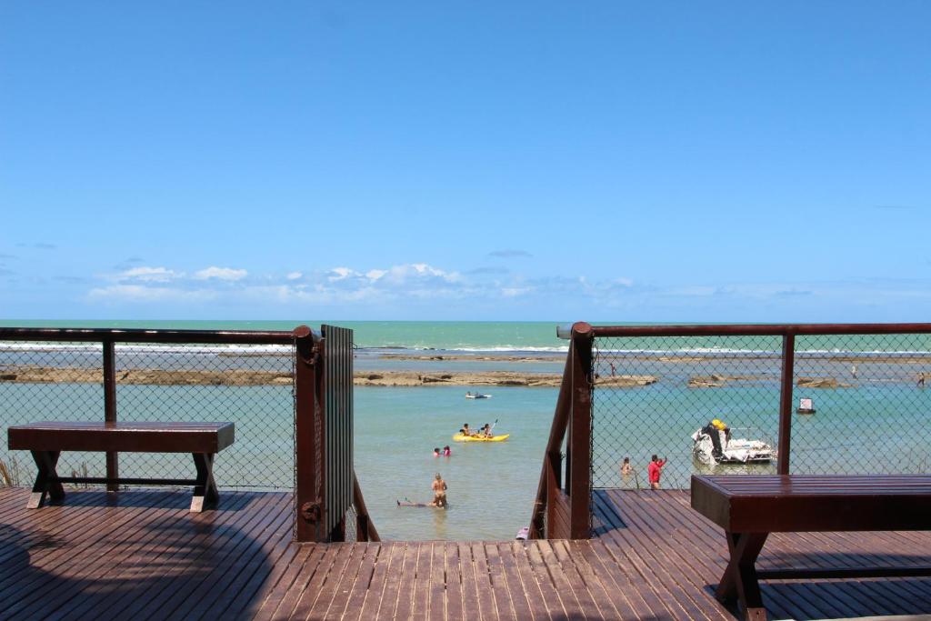 嘎林海斯港Flats Nannai Residence Vilas的和水中的人一起欣赏海滩的景色