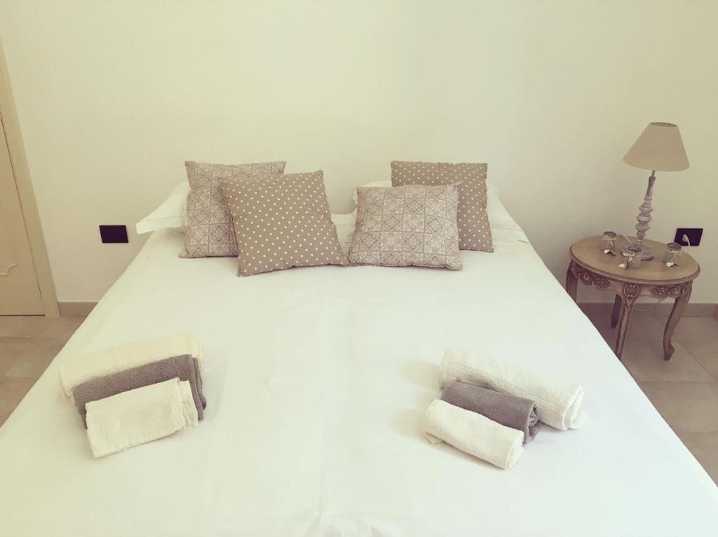 科尔萨诺Monolocale Cora的一张带枕头和桌子的大型白色床