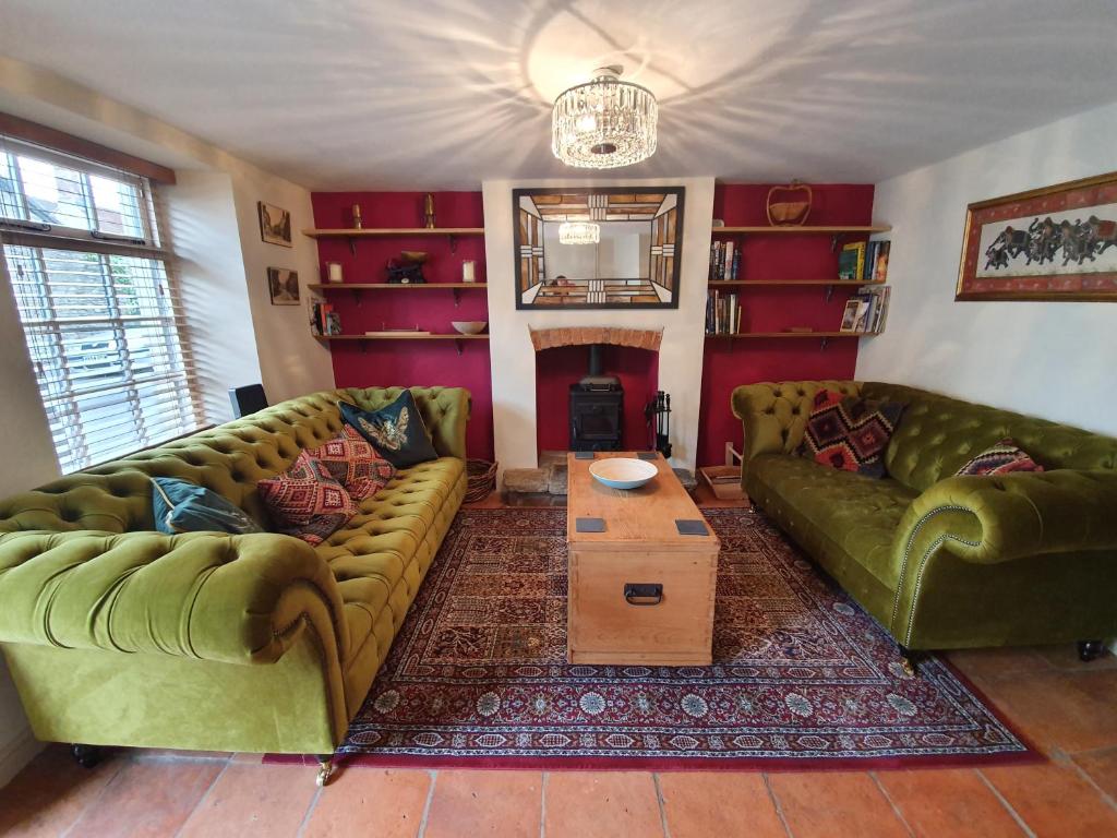 弗罗姆Fern Tree Cottage的客厅配有两张绿色沙发和一张桌子