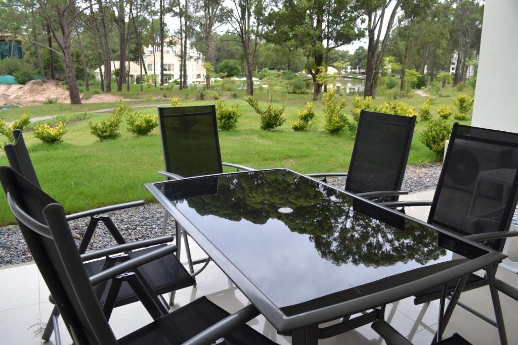 埃斯特角城Green Park 2 Ambientes en PB con Jardín y Parrillero的露台上的玻璃桌子和椅子