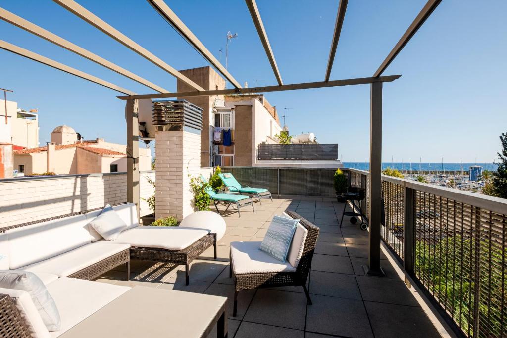 马斯诺Terrassa de Mar Apartment的阳台的天井配有桌椅
