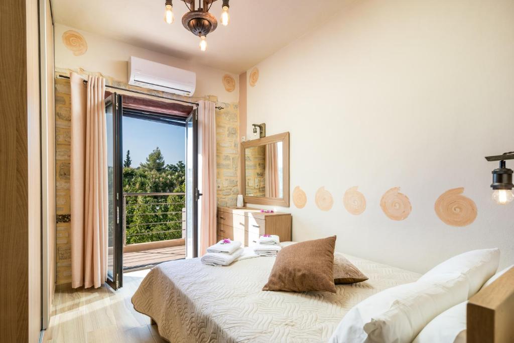 皮特斯迪亚Ferienhaus Aretoussa的一间卧室设有一张床和一个大窗户
