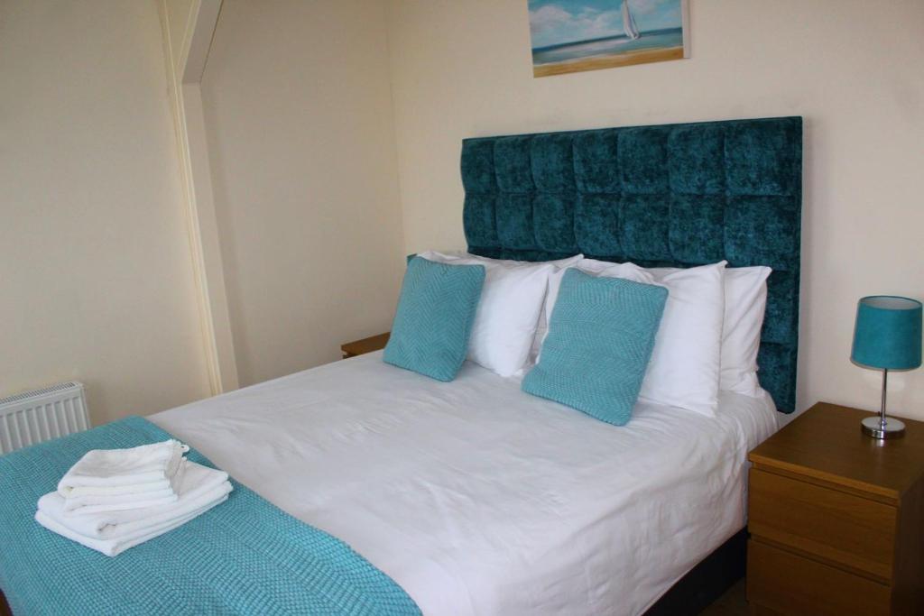 RushThe Beachfront Retreat的一间卧室配有白色床和蓝色枕头