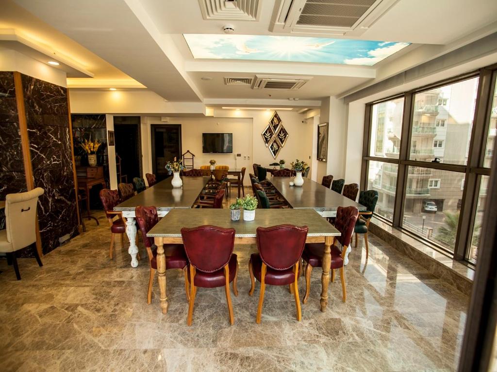 艾登Lion Park Suites & Residence Hotel的一间带大桌子和椅子的用餐室
