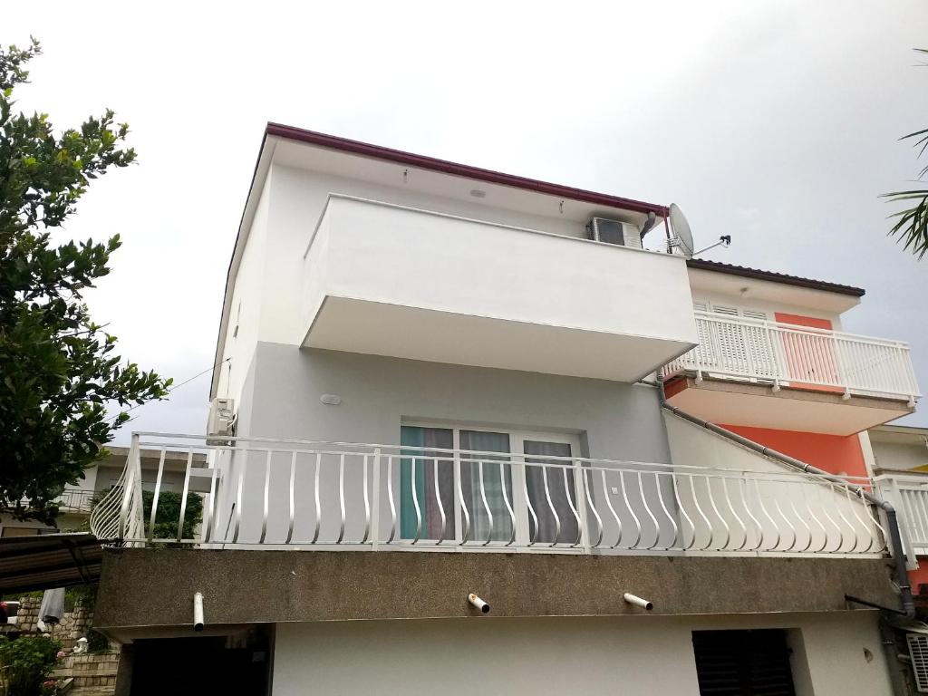 茨里克韦尼察Villa Dora ##3的白色的建筑,带有阳台,上面有冲浪板