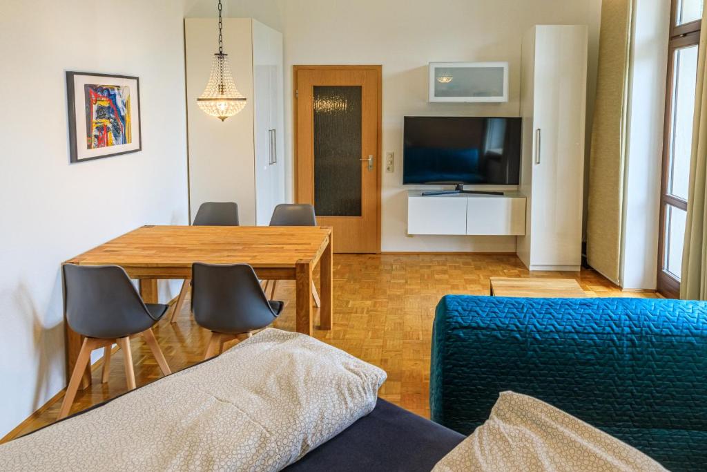 维尔茨堡Charming City Apartment with parking spot的客厅设有餐桌和电视
