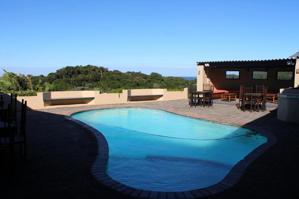 MpumeTHE HAVEN HOTEL的一座大型蓝色游泳池,位于房子旁边