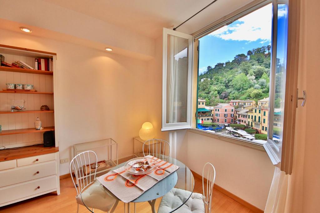 波托菲诺Vela Portofino by KlabHouse的一间带桌子和大窗户的用餐室