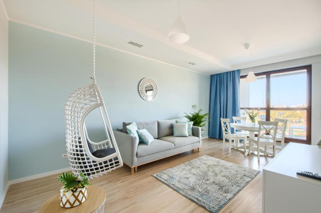 华沙Naviflat - West Side Apartment的客厅配有白色沙发和秋千